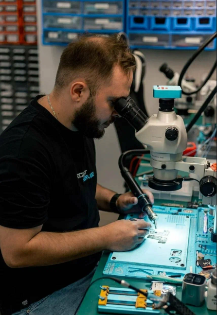 Мастер Rocket Service работает с платой под микроскопом